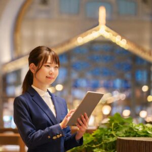 タブレットで運営規程を確認するスーツ姿の日本人女性